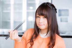箸で食事をする女性イメージ